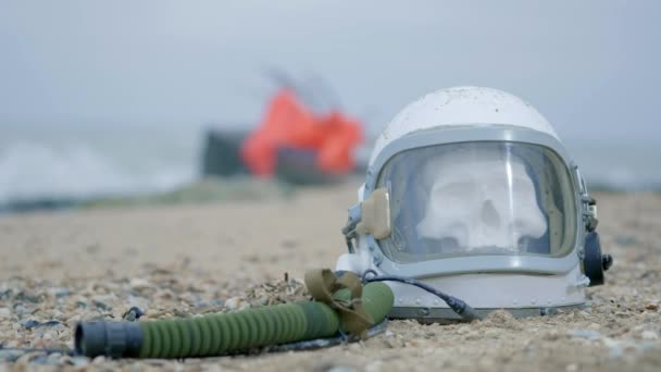 Dead astronaut on the planet. The skull from the head in the helmet lies on the sand by the sea. Troubled by accident. — Stock Video