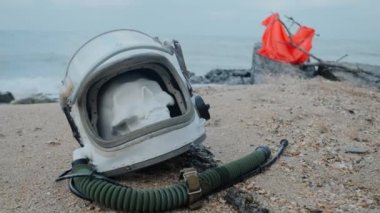 Ölü bir kozmonot Başkanı deniz kum üzerinde yatıyor. Astronot onun uzay gemisinde çöktü. Bulutlu hava, Rüzgar esiyor