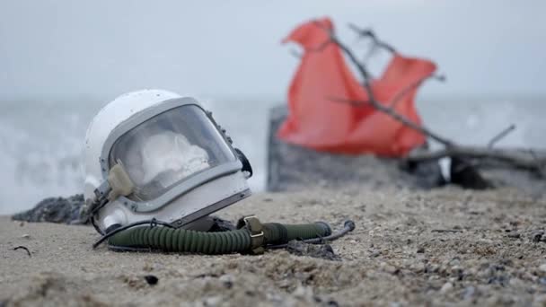 Astronauta muerto en el planeta. El cráneo de la cabeza en el casco se encuentra en la arena junto al mar. Problemas por accidente . — Vídeo de stock