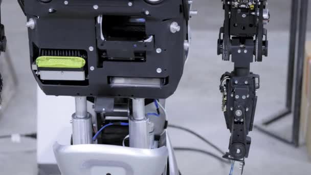 Robot démonté en production. Le robot est prêt pour l'assemblage, lève la main. Usine de production de robots . — Video