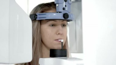 Sarışın genç kadın çene panoramik bir grafisi yapma diş bir X-Ray tarayıcı.