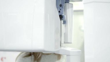 Sarışın genç kadın çene panoramik bir grafisi yapma diş bir X-Ray tarayıcı.