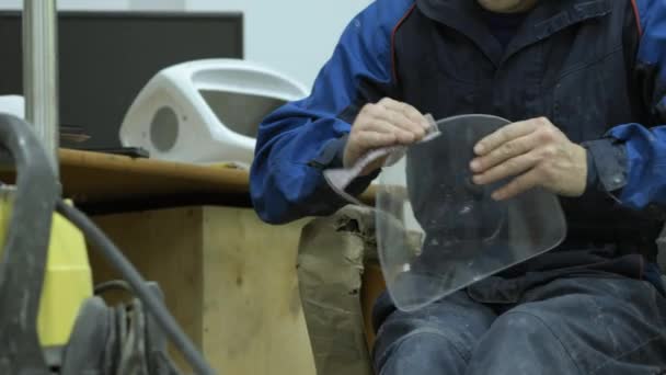 L'ouvrier recueille la tête d'un robot moderne blanc. Essuyez le verre .