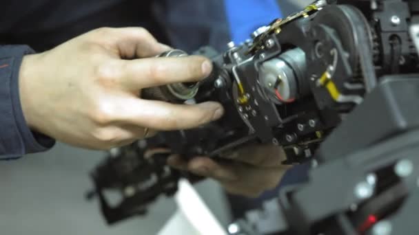 Onderzoeker maakt een moderne robot of android. Controleert het mechanisme in de hand van de robot. Productie en de fabricage van robots. — Stockvideo