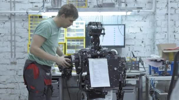 Инженер производит и регулирует современного робота . — стоковое видео