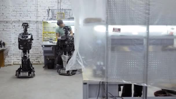 De ingenieur maakt en past de moderne robot. — Stockvideo