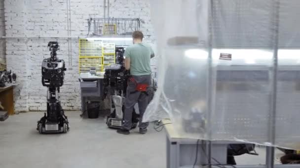 Der Ingenieur fertigt und justiert den modernen Roboter. — Stockvideo