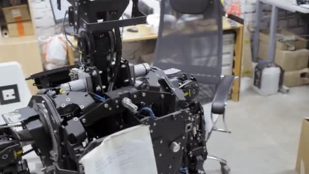 Ingeniero trabajador en la fábrica para la producción de robots. Inventa y crea un nuevo robot. El robot está desmontado, los mecanismos internos y la electrónica son visibles — Vídeos de Stock