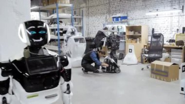 Fabrika Robotlar üretimi için. Mühendis robot inceliyor. Yeni bir robot laboratuarda oluşturur. Onarım robot parçaları.