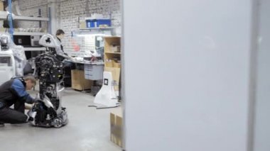 Fabrika Robotlar üretimi için. Mühendis robot inceliyor. Yeni bir robot laboratuarda oluşturur. Onarım robot parçaları.