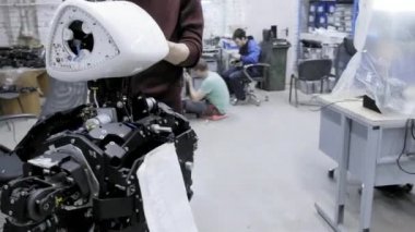Fabrika Robotlar üretimi için. İki mühendis robotlar inceleyin. Yeni robotlar laboratuarda oluşturur. Demonte robot özelleştirmek.