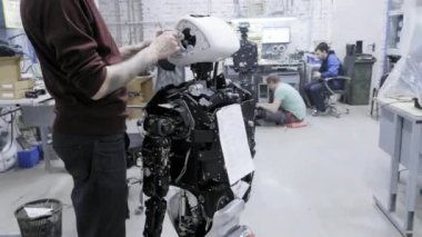 Fabrika Robotlar üretimi için. İki mühendis robotlar inceleyin. Yeni robotlar laboratuarda oluşturur. Demonte robot özelleştirmek.