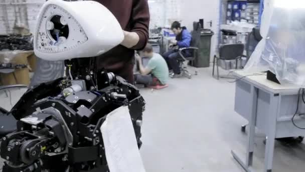 Fabrik für die Produktion von Robotern. Zwei Ingenieure inspizieren Roboter. schafft neue Roboter im Labor. zerlegte Roboter individuell anpassen. — Stockvideo