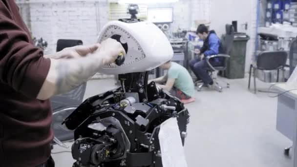 Fábrica para a produção de robôs. Dois engenheiros inspecionam robôs. Cria novos robôs no laboratório. Personalizar robô desmontado . — Vídeo de Stock