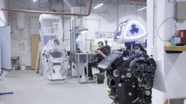 Fabrika Robotlar üretimi için. Robot değer, gülümseyen demonte