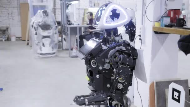 Fábrica para la producción de robots. El robot vale la pena desmontarlo, sonriendo — Vídeo de stock