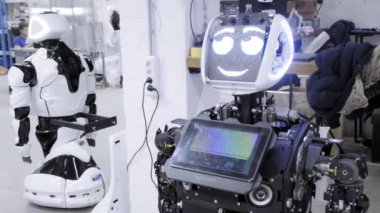 Fabrika Robotlar, modern robot gelişmeler üretimi için. Bir grup mühendis yeni bir robot yaratmak için çalışıyoruz. Eski bir robot ayrı ayrı atölye standları.