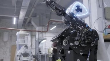 Fabrika Robotlar, modern robot gelişmeler üretimi için. Demonte robot tebrik elinde ve dansları atölye dalgalar. Mühendisler yürüyüş içinde belgili tanımlık geçmiş.