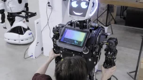 Fabrik für die Produktion von Robotern, moderne Roboterentwicklungen. überprüft der Ingenieur die Arbeitsmechanismen des Roboters. schafft einen Roboter — Stockvideo