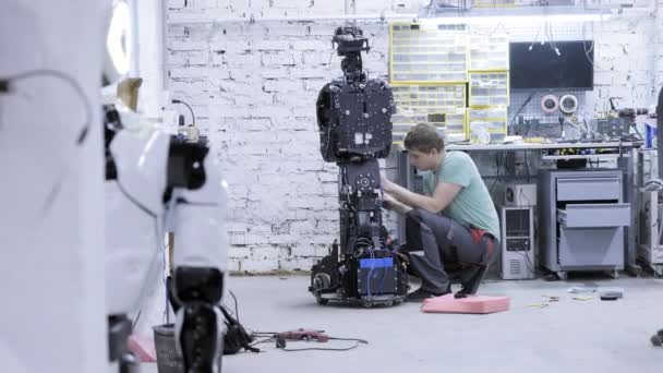 Fabriek voor de productie van robots, moderne robot ontwikkelingen. Ingenieur maakt de indringende robot. — Stockvideo