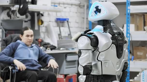 Fabrik für die Produktion von Robotern. Wissenschaftler reflektiert das Gerät des Roboters. richtet ein und nimmt Anpassungen vor, schafft einen neuen Roboter — Stockvideo