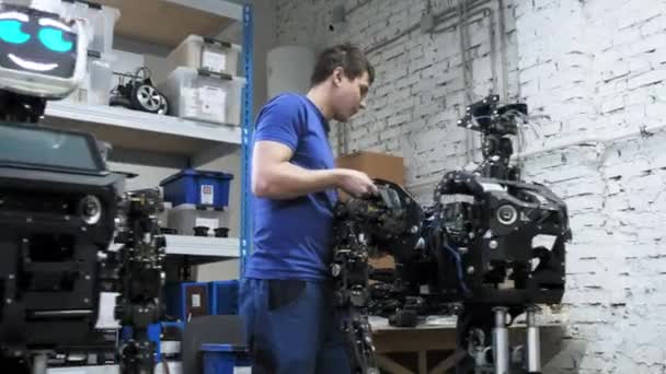 本厂生产机器人 工程师将手的一个单独的部分连接到新机器人的身体上 创建机器人 — 图库视频影像