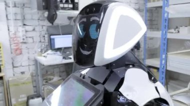 Fabrika Robotlar üretimi için. Mühendis robotun kafasına teller bağlanır.