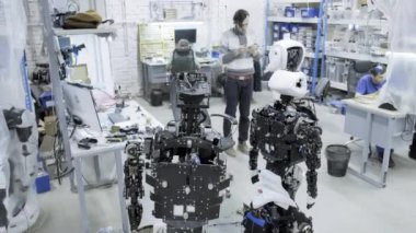 Fabrika Robotlar, modern robot gelişmeler üretimi için. Bir grup genç mühendis yeni modern robotlar oluşturur. Robotlar dükkanda demonte.