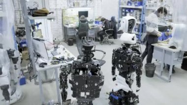 Fabrika Robotlar, modern robot gelişmeler üretimi için. Bir grup genç mühendis yeni modern robotlar oluşturur. Robotlar dükkanda demonte.