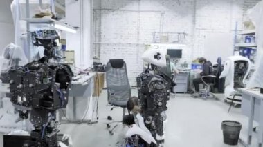 Fabrika Robotlar, modern robot gelişmeler üretimi için. Bir grup genç mühendis yeni modern robotlar oluşturur. Robotlar dükkanda demonte.