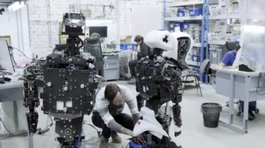 Fabrika Robotlar, modern robot gelişmeler üretimi için. Bir grup genç mühendis yeni modern robotlar oluşturur. Robotlar dükkanda demonte.