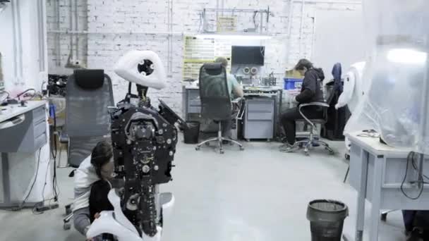 Fabriek voor de productie van robots, moderne robot ontwikkelingen. Een groep jonge ingenieurs maakt nieuwe moderne robots. Robots zijn gedemonteerd in de winkel. — Stockvideo