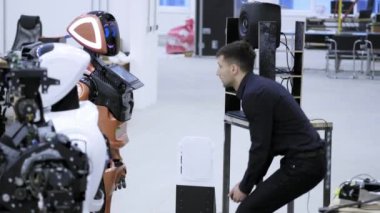 Fabrika Robotlar üretimi için. Mühendis robot konuşma öğretir, görüşmeler için robot, robot yanıtlarını dinler.
