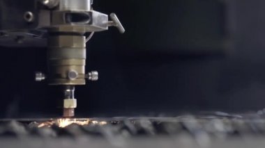 Atölyede sac kesme. Ağır sektörde modern bir araçtır. Tehlikeli bir iş. Çelik parçaların yüksek hassasiyetli imalatı. Metal, modern endüstriyel makine CNC lazer kesim. Küçük alan derinliği.