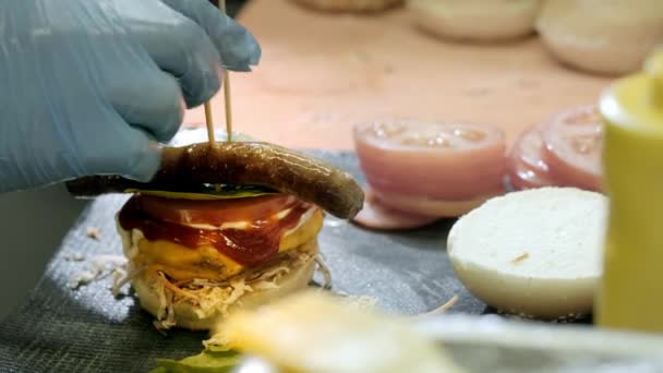 Mãos a preparar um hambúrguer. Vista de perto da preparação de um hambúrguer de carne no festival de comida de rua. Chef prepara fast food no restaurante . — Vídeo de Stock
