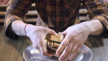 adam yeme, peynir ve sebze ile lezzetli büyük Burger eti tatma sahiptir. Close. Sağlıklı beslenme ve obezite toplumu kavramı