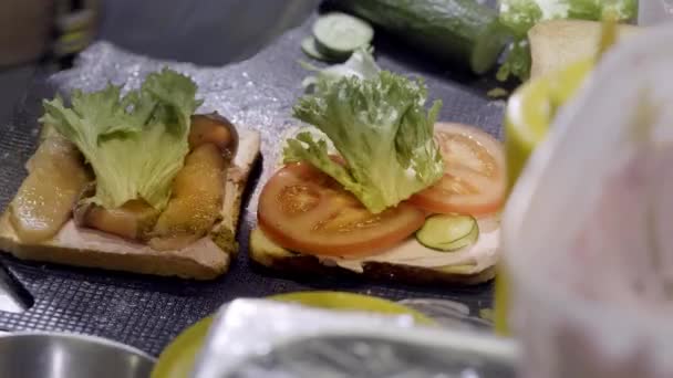 Préparation d'un sandwich au jambon et fromage suisse sur pain blanc. Gros plan. le cuisinier prépare un sandwich — Video