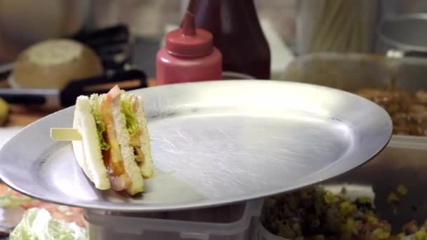Preparação de sanduíche com presunto e queijo suíço sanduíche no pão branco. close-up. o cozinheiro está preparando um sanduíche — Vídeo de Stock