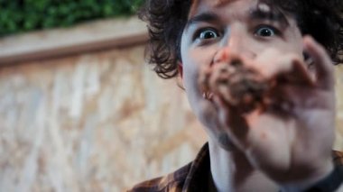 Genç bir adam çirkin ve kaba bir şekilde sandviç yiyor. Hızlı yemek yiyor. Obezite toplumun kavramı ve kötü beslenme. komik video.