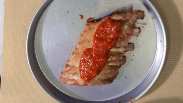 Згладжування та покриття свинячих ребер соусом з барбекю — стокове відео