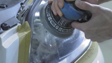 Far parlatma, Araba ışıkları işleme. Bir araba servis işçisi özel bir parlatma aracı ile bir binek aracın Far parlatır. Profesyonel parlatma