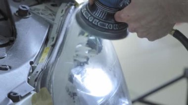Far parlatma, Araba ışıkları işleme. Bir araba servis işçisi özel bir parlatma aracı ile bir binek aracın Far parlatır. Profesyonel parlatma