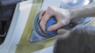 Far parlatma, Araba ışıkları işleme. Bir araba servis işçisi özel bir parlatma aracı ile bir binek aracın Far parlatır. Profesyonel parlatma