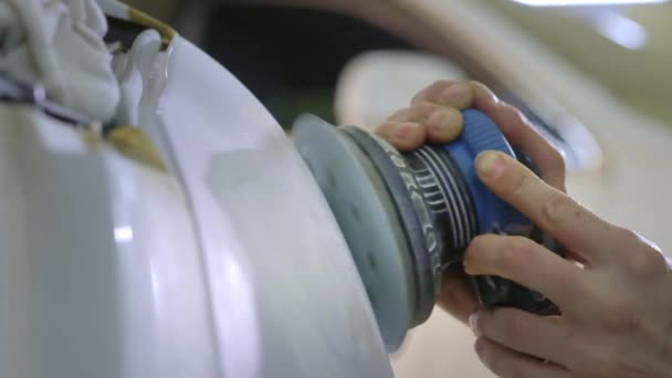 Koplamp polijsten, verwerking van auto lichten. Een Autoservice werknemer polijst de koplamp van een personenauto met een speciale polijsten tool. Professioneel polijsten — Stockvideo