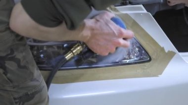 Far parlatma, Araba ışıkları işleme. Bir araba servis işçisi özel bir parlatma aracı ile bir binek aracın Far parlatır. Profesyonel parlatma