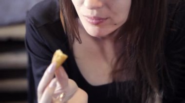 Seksi genç kız bir kafede hızlı yemek yiyor. Close. Bir parça patates kızartması. Hızlı snack ve obezite toplumun kavramı.