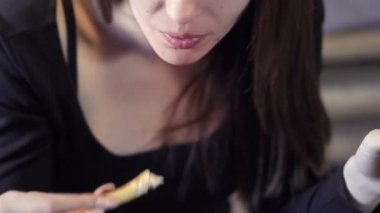 Seksi genç kız bir kafede hızlı yemek yiyor. Close. Bir parça patates kızartması. Hızlı snack ve obezite toplumun kavramı.