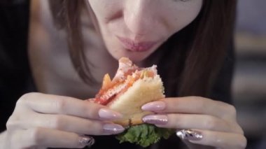 Seksi genç kız sedvich yiyor. Close. Hızlı snack ve obezite toplumun kavramı. Serbest meslek için gıda
