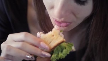 Seksi genç kız sedvich yiyor. Close. Hızlı snack ve obezite toplumun kavramı. Serbest meslek için gıda