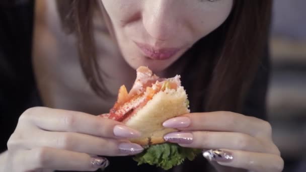 Sexy ragazza mangia sedvich. Primo piano. Il concetto di spuntino veloce e società dell'obesità. Cibo per freelance — Video Stock